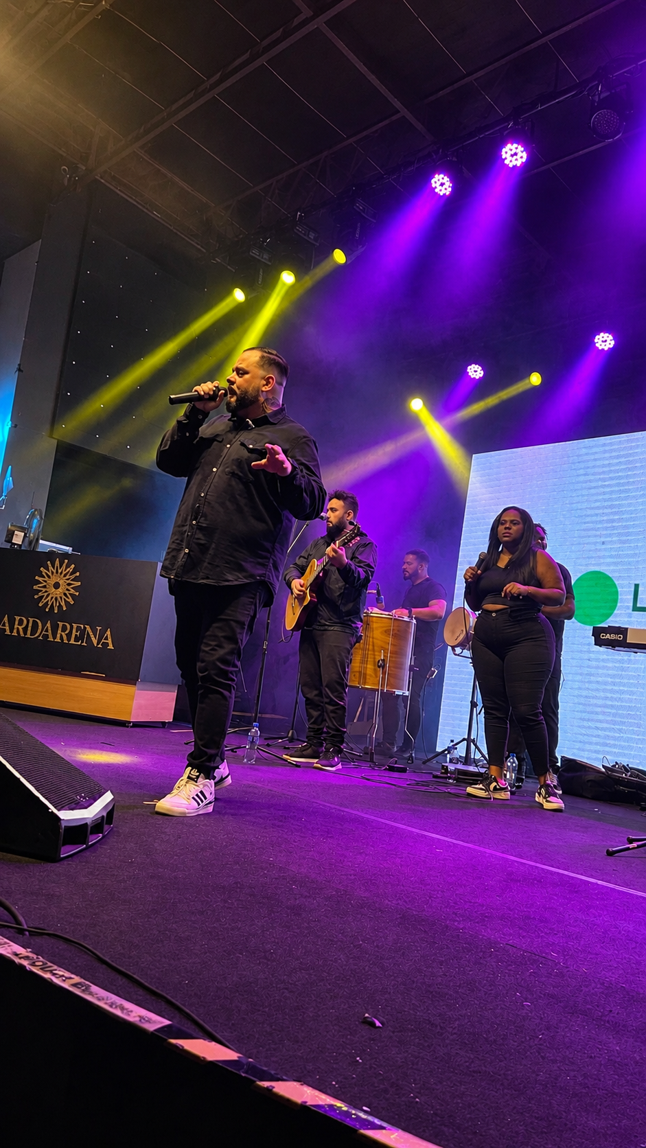 Tudo D!ferente em apresentação ao vivo sob luzes roxas e douradas